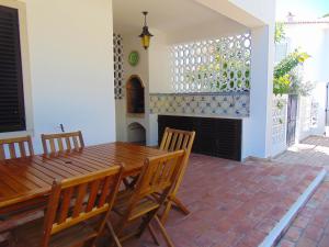 a dining room with a wooden table and chairs at Vila Ninita in Vilamoura