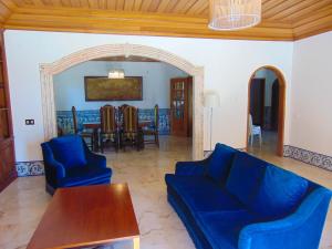 uma sala de estar com sofás azuis e uma mesa em Vila Ninita em Vilamoura