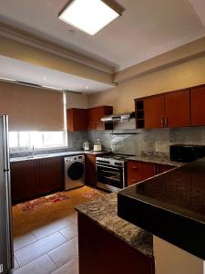 eine Küche mit Holzschränken und einem Herd mit Backofen in der Unterkunft Urban 2 Bedroom Serviced Apartment in Nakasero in Nalakonge