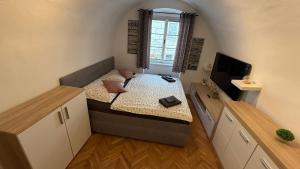 Cette petite chambre comprend un lit et une télévision. dans l'établissement Apartment Široká 52, à Český Krumlov 3 autres photos