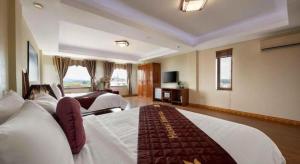 ein großes Hotelzimmer mit zwei Betten und einem Fernseher in der Unterkunft Viet Village Hotel in Noi Bai + 198 Fotos