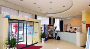 eine Lobby eines Ladens mit einer Theke und zwei Personen in der Unterkunft Jinjiang Inn Jinan Daming Lake in Jinan