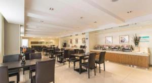 a dining room with tables and chairs in a restaurant at Jinjiang Inn Weihai Liugong Island Scenic Spot Shopping Market in Weihai