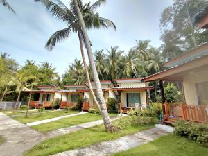 a house with a palm tree in front of it at Nathan Breeze Resort in Ko Muk