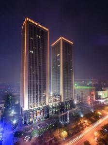 two tall buildings in a city at night at Shanxi World Trade Hotel in Taiyuan