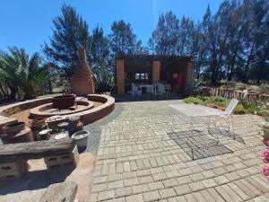 einen Hinterhof mit einer Feuerstelle und einer Terrasse in der Unterkunft Sundown Lodge and Confrence in Aliwal North