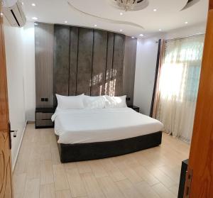 a bedroom with a large white bed with a wooden headboard at منتجع الكناري in Taif +70 photos