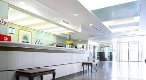 eine Lobby eines Krankenhauses mit zwei Stühlen und einer Theke in der Unterkunft Pearl Hotel Kawasaki in Kawasaki