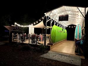 Ein Zelt mit einem großen grünen Gegenstand unter einem weißen Dach in der Unterkunft Cozy Cottage with River Access for a Fun-Filled Getaway by the Rainbow River in Florida in Dunnellon