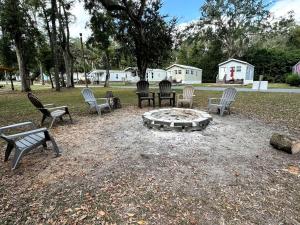 eine Gruppe von Stühlen, die um eine Feuerstelle herum sitzen in der Unterkunft Cozy Cottage with River Access for a Fun-Filled Getaway by the Rainbow River in Florida in Dunnellon