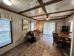ein Wohnzimmer mit Sofa und Tisch in der Unterkunft Cozy Cottage with River Access for a Fun-Filled Getaway by the Rainbow River in Florida in Dunnellon
