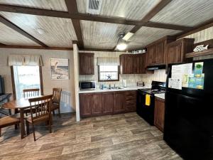 eine Küche mit einem Tisch und einem schwarzen Kühlschrank in der Unterkunft Cozy Cottage with River Access for a Fun-Filled Getaway by the Rainbow River in Florida in Dunnellon