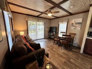ein Wohnzimmer mit Sofa und Tisch in der Unterkunft Cozy Cottage with River Access for a Fun-Filled Getaway by the Rainbow River in Florida in Dunnellon + 45 Fotos