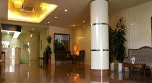 eine Lobby mit einer Säule in der Mitte eines Raumes in der Unterkunft Isehara Green Palace Hotel in Isehara
