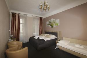 a hotel room with two beds and a chandelier at City Hotel Gotland in Berlin