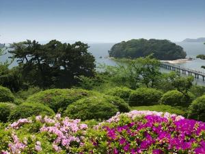 ein Blumenfeld mit Blick auf das Wasser in der Unterkunft Hotel Shofuen in Miya