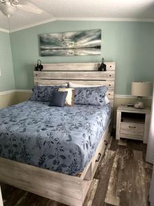 ein Schlafzimmer mit einem großen Bett mit einem hölzernen Kopfteil in der Unterkunft Stunning Cottage by the Rainbow River with Fantastic Amenities for a Wonderful Florida Escape in Dunnellon