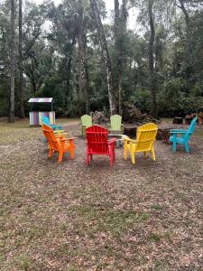 eine Gruppe bunter Stühle im Gras in der Unterkunft Stunning Cottage by the Rainbow River with Fantastic Amenities for a Wonderful Florida Escape in Dunnellon