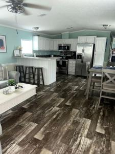 eine Küche mit Holzböden und eine Küche mit einem Tisch in der Unterkunft Stunning Cottage by the Rainbow River with Fantastic Amenities for a Wonderful Florida Escape in Dunnellon + 33 Fotos