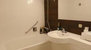 ein weißes Badezimmer mit Waschbecken und Badewanne in der Unterkunft Green Hill Hotel Onomichi in Kaneyoshi