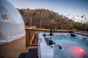 einen Whirlpool auf einer Terrasse neben einem Zelt in der Unterkunft Romantic Geodesic Dome with Hot Tub, Perfect for Stargazing in Pipestem, West Virginia in Pipestem