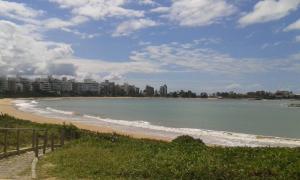 - une vue sur une plage avec des bâtiments en arrière-plan dans l'établissement Pousada Enseada do Coqueiro, à Guarapari