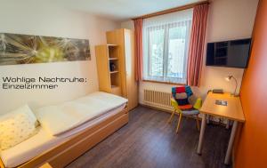 Camera piccola con letto, scrivania e sedia. di Kessler's Kulm Gästehaus a Davos