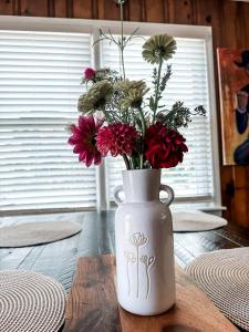 eine weiße Vase mit Blumen auf dem Tisch in der Unterkunft Beautiful Farm Stay with Private Pickleball Court near Kerr Lake, North Carolina in Manson + 23 Fotos