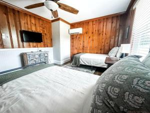 ein Schlafzimmer mit zwei Betten und einem Deckenventilator in der Unterkunft Beautiful Farm Stay with Private Pickleball Court near Kerr Lake, North Carolina in Manson