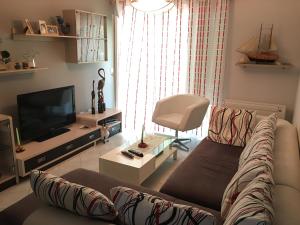 a living room with a couch and a television at Apartment Eurocoli Rezidence in Golem