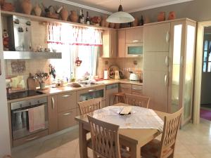 a kitchen with a table and a table and chairs at Apartment Eurocoli Rezidence in Golem +11 photos