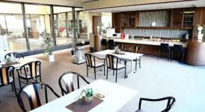 a restaurant with tables and chairs and a counter at HOTEL WINDSOR in Nakatsugawa