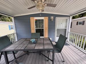 einen Tisch und Stühle auf einer Terrasse mit einem Deckenventilator in der Unterkunft Modern Cottage with Incredible Amenities and Rainbow River Access near Dunnellon, Florida in Dunnellon