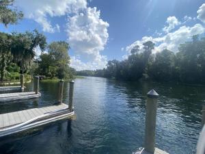 Blick auf einen Fluss mit einem Holzsteg in der Unterkunft Modern Cottage with Incredible Amenities and Rainbow River Access near Dunnellon, Florida in Dunnellon