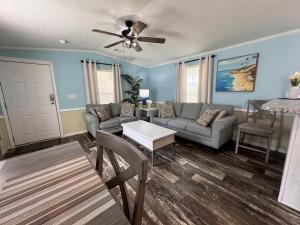 ein Wohnzimmer mit Sofa und Tisch in der Unterkunft Modern Cottage with Incredible Amenities and Rainbow River Access near Dunnellon, Florida in Dunnellon