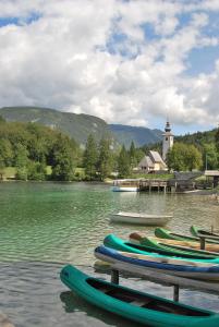 a bunch of kayaks sitting on a dock in the water at Apartments & Rooms Malej in Bohinj