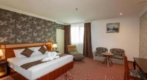 a hotel room with a large bed and a desk at Pelican Hotel in Batu Pahat +139 photos