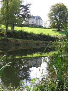 uma casa sentada numa colina ao lado de um corpo de água em Domaine de Gaudon em Ceilloux