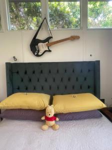 ein Teddybär, der auf einem Bett sitzt in der Unterkunft Waterberry Hideaway in Pringle Bay