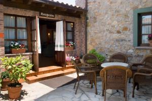 een patio met een tafel en stoelen en een gebouw bij Hotel Rural Entremontes in Cangas de Onís