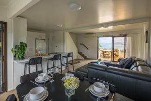 a living room with a couch and a table at Seaviews and a stroll to Whanagaumu bay in Whangarei