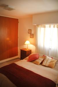 1 dormitorio con 1 cama con lámpara y ventana en Depto En El Centro - Dean Funes en Córdoba