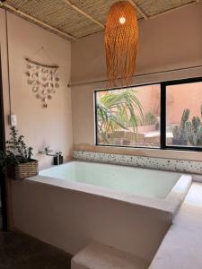 eine große Badewanne in einem Raum mit Fenster in der Unterkunft The Chan Chan Home Seaside Phan Thiet in Phan Thiet