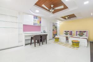 a living room with a table and chairs and a couch at FabHotel Pink Cozzy in Jaipur