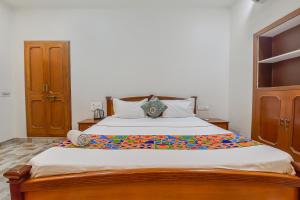 a bedroom with a large bed with a wooden frame at FabHotel Pink Cozzy in Jaipur +26 photos