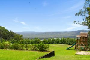 ein Spielplatz mit einer Rutsche auf einer Wiese in der Unterkunft Coastview Manor - Family Hinterland Retreat in Valdora