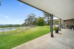 eine Außenterrasse mit einem Zaun und Gras in der Unterkunft Coastview Manor - Family Hinterland Retreat in Valdora