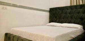 a bed with a black headboard and two pillows on it at ftrealtyproperties Lords Hill in Tokuse +6 photos