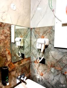 a bathroom with a sink and a mirror at Hotel Pratyaksh Darshan in Varanasi +8 photos