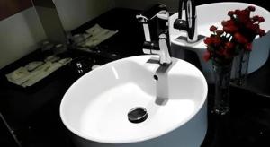 ein weißes Waschbecken im Bad mit einer Blumenvase in der Unterkunft Super 8 Hotel Xi'an Dayan Tower Heping Gate Metro Station in Xi'an